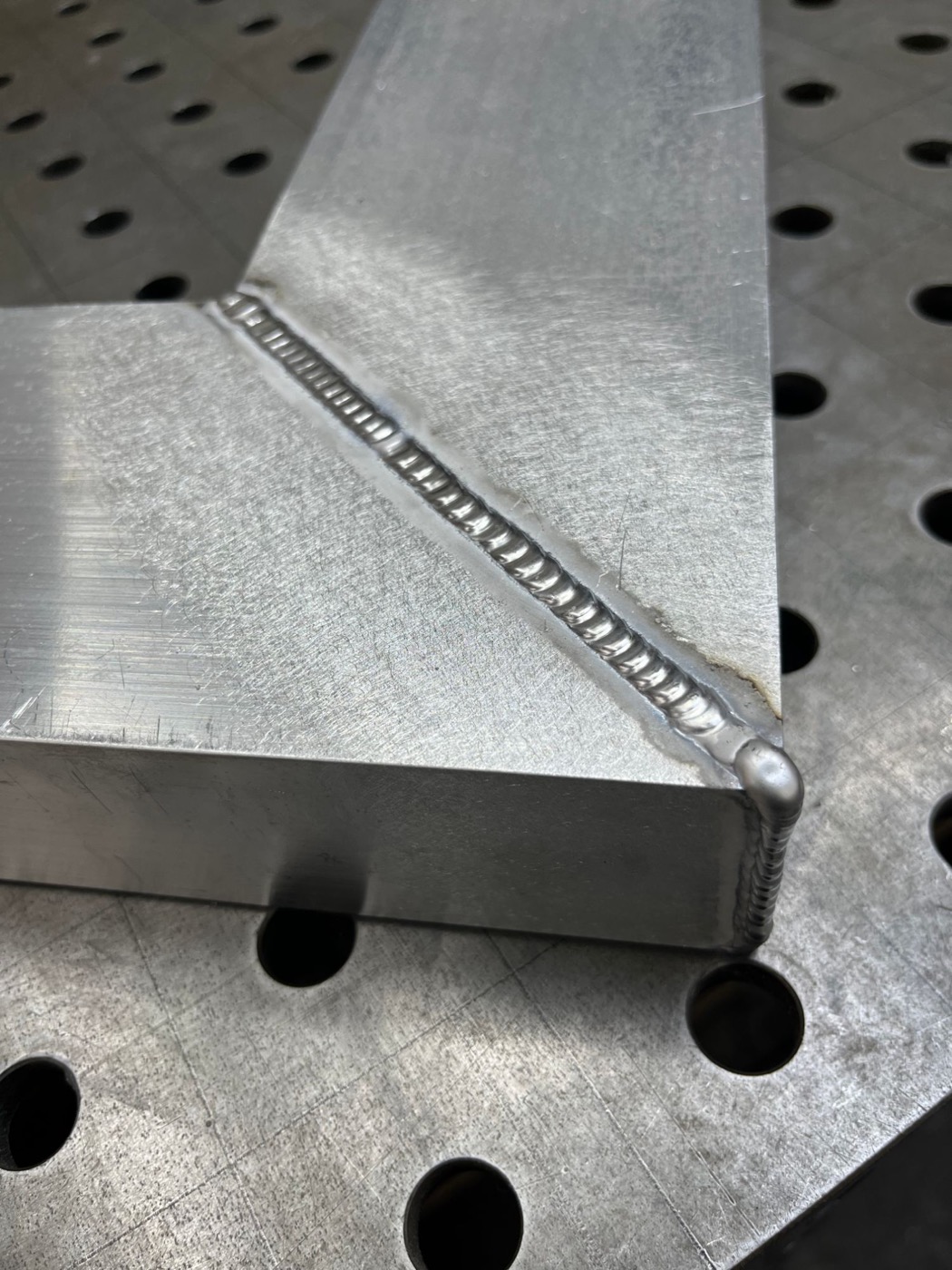 Close-up of a TIG weld on a mitered aluminum corner